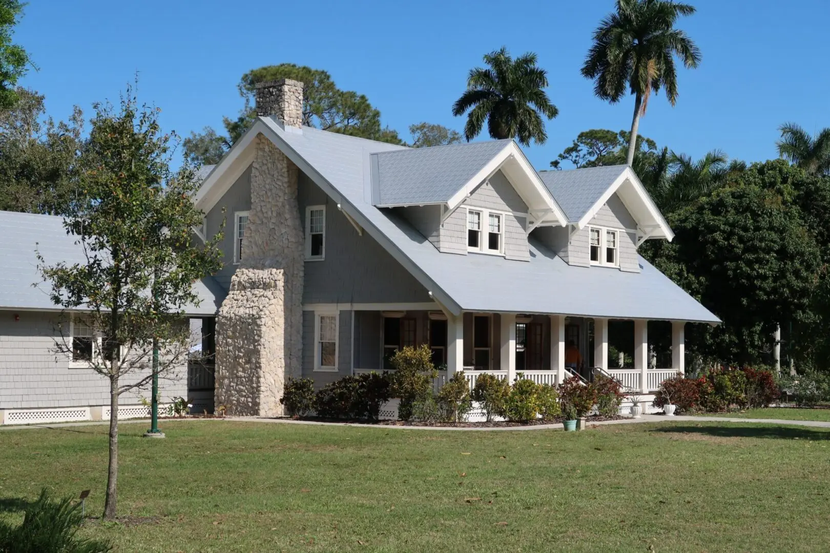 A gray and white house with a front yard